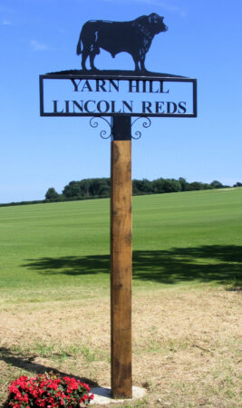 Lincoln Red Bull Hot Forged Picture Farm Sign - Installed atop a wooden post