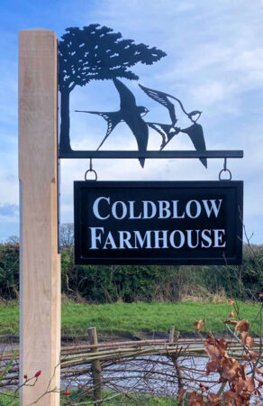 Pair of flying swallows with tree hanging bracket sign installed